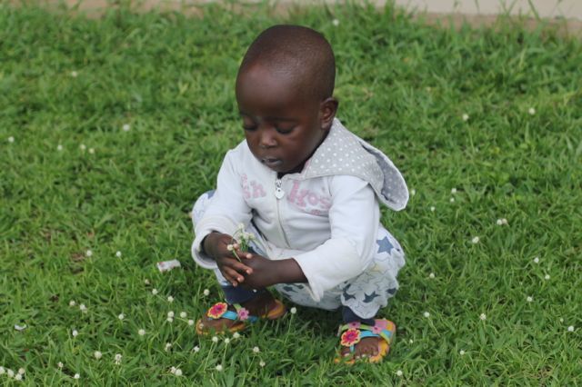 Rwandan cardiac patient Joy picking flowers